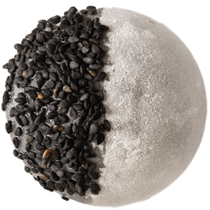 Mochi noir couvert de graines de sésame noires et de pépites de chocolat, sur un fond noir élégant.